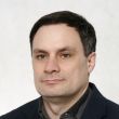 Zdjęcie portretowe: dr hab. inż. Michał Kaczmarek, prof. PŁ w czarnej marynarce i ciemnej koszuli na jasnym tle.