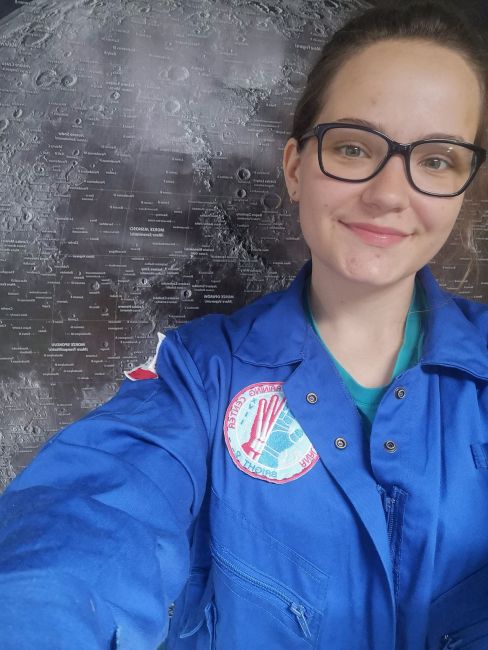 Portrait photo: Aleksandra Wilczyńska, a TUL student, wearing a blue jacket against a dark background.
