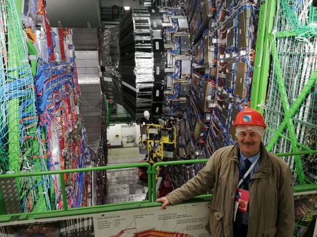 Prof. Piotr Borkowski w CERN, na tle detektora cząstek elementarnych CMS, Wielkiego Zderzacza Hadronów