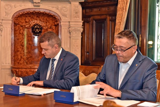 Prorektor prof. A. Romanowskiego oraz A. Michalski podpisują umowę.