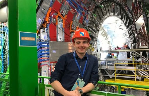 Zdjęcie portretowe: Michał Maciejewski w czerwonym kasku w hali Europejskiej Organizacji Badań Jądrowych CERN