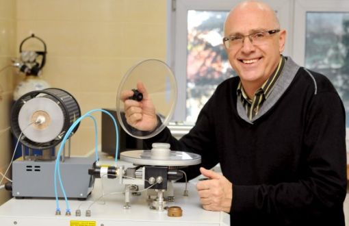 Zdjęcie portretowe: prof. Piotr Paneth siedzi przy stanowisku laboratoryjnym.