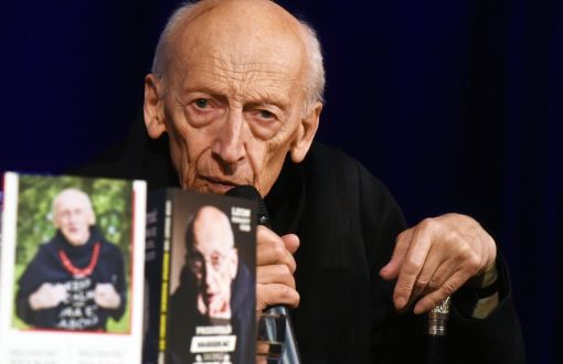 Ojciec Leon Knabit w ciemnym habicie z mikrofonem w ręce podczas spotkania w ramach cyklu "Czwartkowe Forum Kultury".