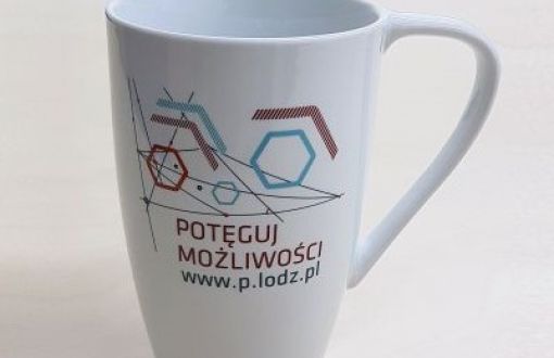 Biały kubek ceramiczny z uchem z abstrakcyjną grafiką i napisem Potęguj możliwości i adresem strony www.p.lodz.pl/