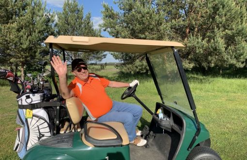 Prof. Piotr Kula za kierownicą samochodu golfowego.