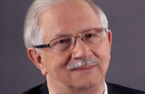Zdjęcie portretowe: prof. Jan Krysiński w ciemnym garniturze, białej koszuli i fioletowym krawacie na ciemnym tle.