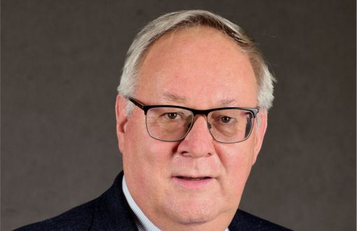 Zdjęcie portretowe: prof. Grzegorz Wielgosiński, dziekan WIPOŚ,  w garniturze na szarym tle.