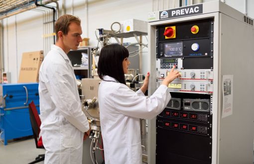 Studenci PŁ w białych fartuchach w laboratorium.