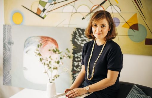 Aleksandra Przedecka na tle swoich prac malarskich.