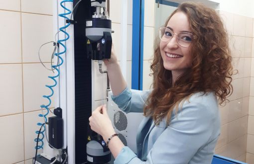 Karolina Wilgocka stoi przy maszynie.