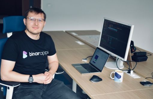 Konrad Klimczak siedzi przy biurku z laptopem.