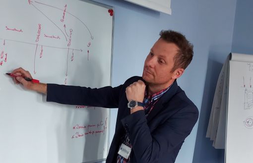 Paweł Filarczyk pisze na białej tablicy.