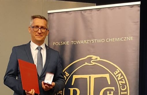 prof. Łukasz Albrecht prezentuje medal im. Stanisława Kostaneckiego i dyplom