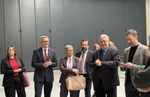 sześć osób stoi na tle szarej ściany